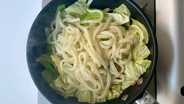 材料が馴染んだらうどんを加える